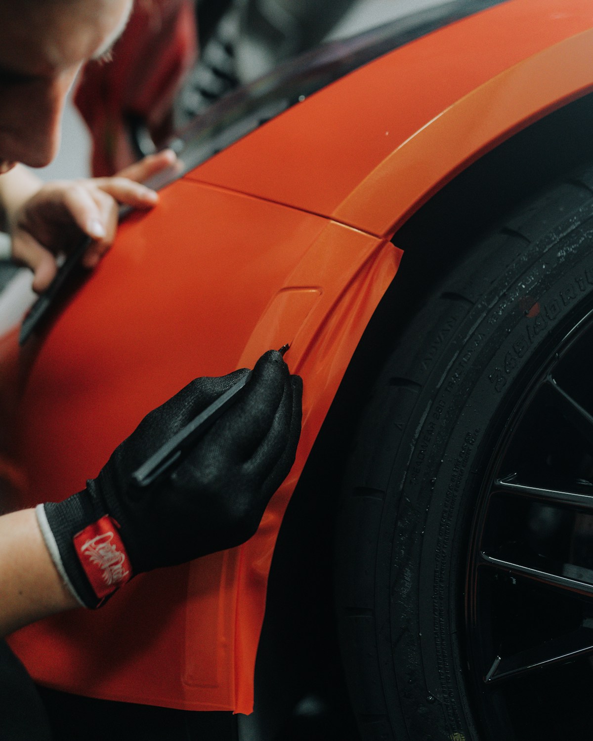 Installer applying vinyl wrap to a fender